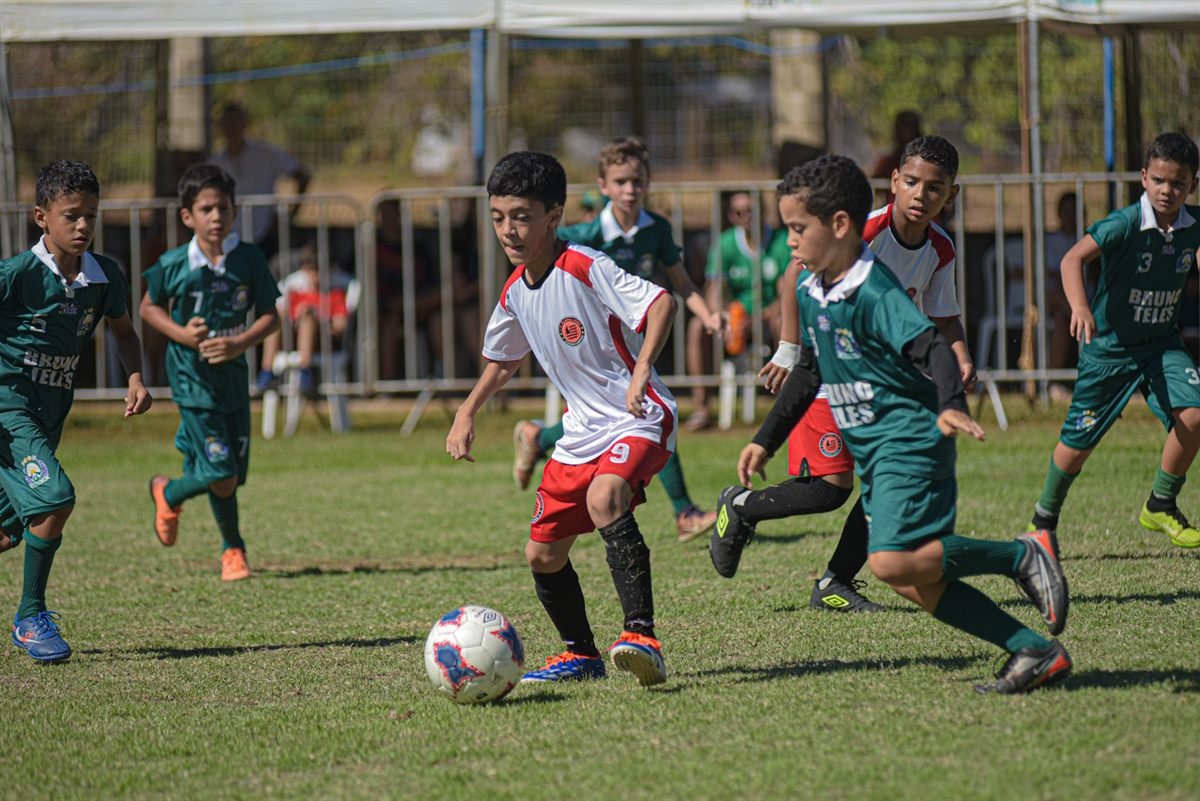 Jogada com vários atletas disputando a bola em campo
